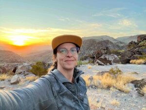 A white woman in her 40s wearing a baseball cap takes a selfie along FM 170 in far west Texas